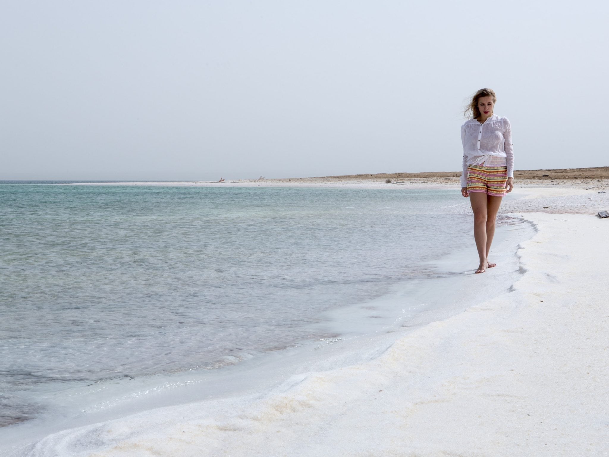 woman walking along the dead sea coastline